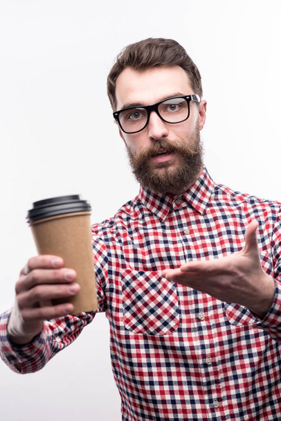 Handsome bearded man offering a cup of coffee - 写真・画像