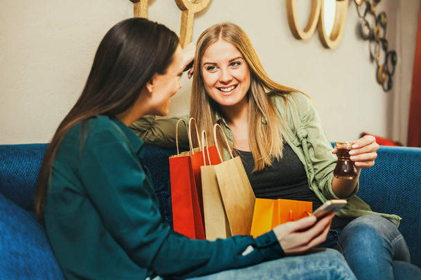 Due donne felici sono seduti in caffè e planing shopping
.  - Foto, immagini