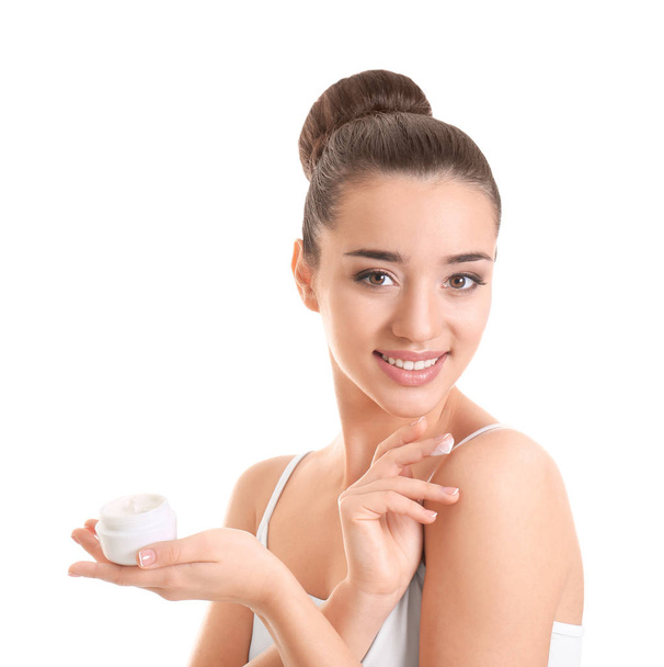 Young woman applying body cream on white background - 写真・画像