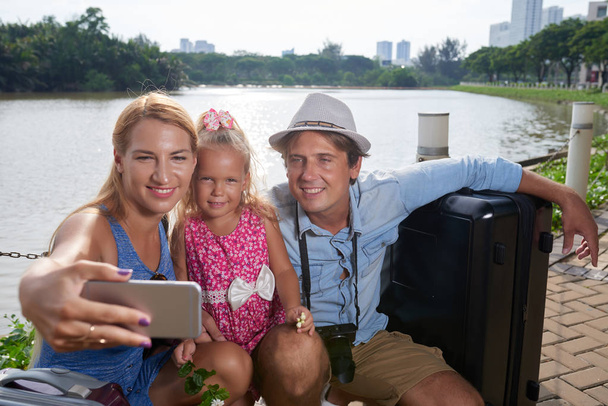 陽気な家族が一緒に都市河川に対する撮影 - 写真・画像