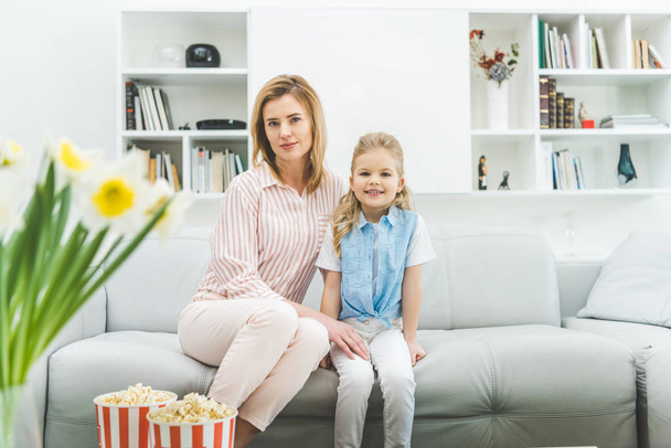 sorridente figlia e madre seduta sul divano in soggiorno
 - Foto, immagini