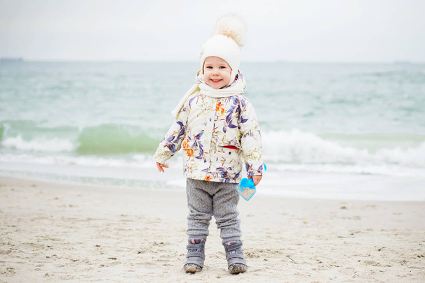 Menina bonito jogando na praia de areia. Criança feliz vestindo
 - Foto, Imagem