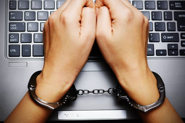 Концепция киберпреступлений вид сверху на руки с наручниками над клавиатурой ноутбука
 - Фото, изображение