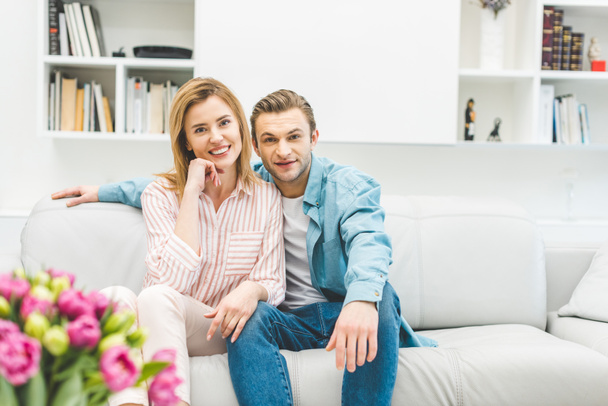 portrait of smiling couple resting on sofa at home - Foto, immagini
