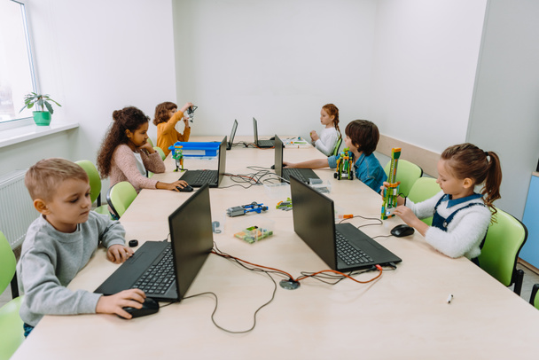 група зосереджених дітей, що працюють з комп'ютерами на класі машин
 - Фото, зображення