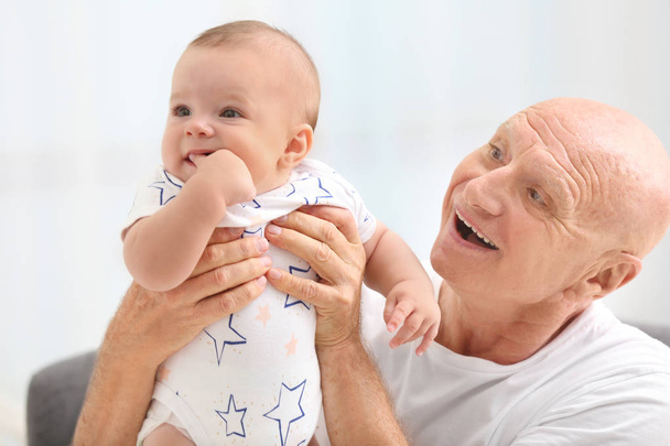Senior man playing with his little grandchild at home - Photo, Image