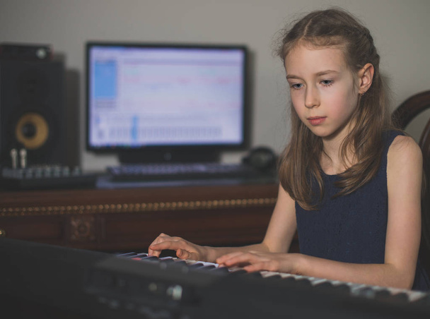 Εγγραφή τραγούδι στο πιάνο σε στούντιο μουσική στο σπίτι το μικρό κορίτσι. - Φωτογραφία, εικόνα