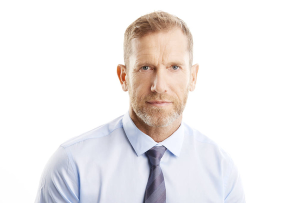 Close-up shot of a middle aged businessman looking at camera while standing against at isolated white background.  - Фото, изображение