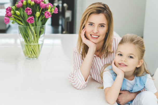 portrait of smiling mother and daughter at home - Фото, зображення