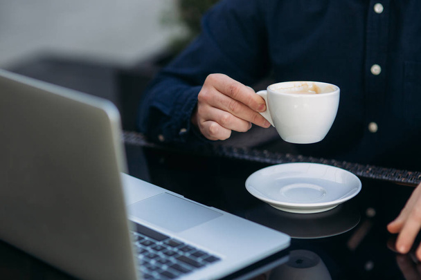 A fiatal menedzser működő-ra egy laptop, a kávé szünet. Ebédszünet. - Fotó, kép