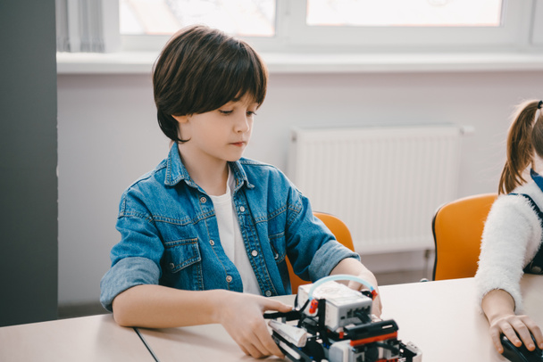 serious little kid making diy robot, stem education concept - Fotó, kép
