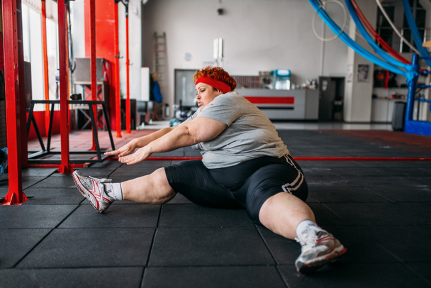 толстая женщина упражнения на полу, тренировки в тренажерном зале
 - Фото, изображение