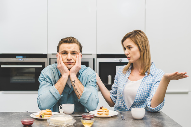 portrait of couple having argument during breakfast at home - Fotó, kép