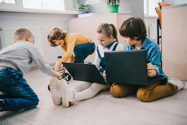 щасливі діти, що працюють з ноутбуками на підлозі, концепція освіти стовбурів
 - Фото, зображення