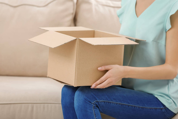 Woman with parcel at home - Foto, Bild