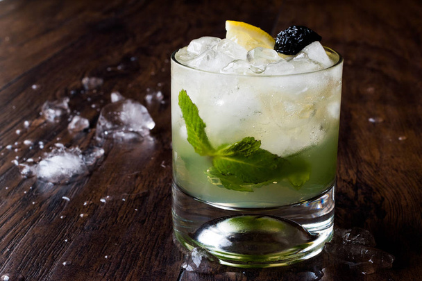 Whiskey Smash Cocktail with Mint Leaves, Lemon, Olive and Crushed Ice.  - Фото, изображение