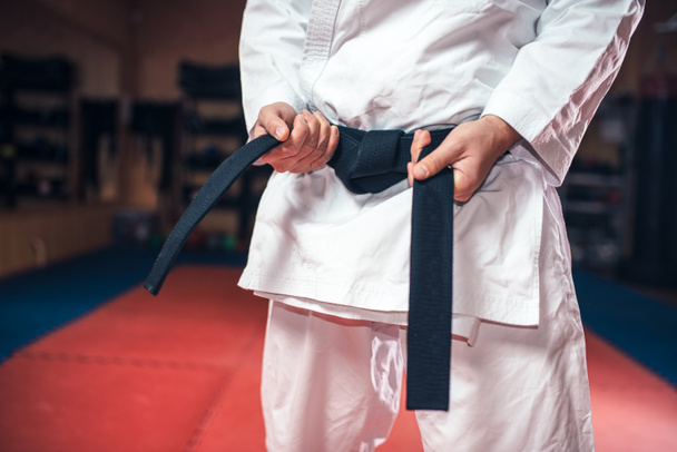 fighter in white kimono with black belt, karate training in gym - 写真・画像
