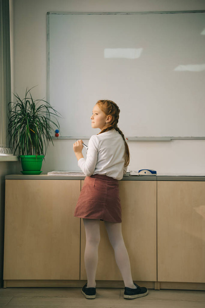 αξιολάτρευτο μικρό μαθήτρια που στέκεται στο μέτωπο whiteboard - Φωτογραφία, εικόνα