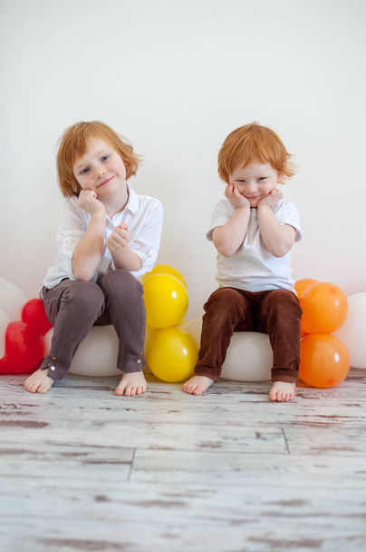 Αδελφός και αδελφή κάθονται σε μπαλόνια - Φωτογραφία, εικόνα