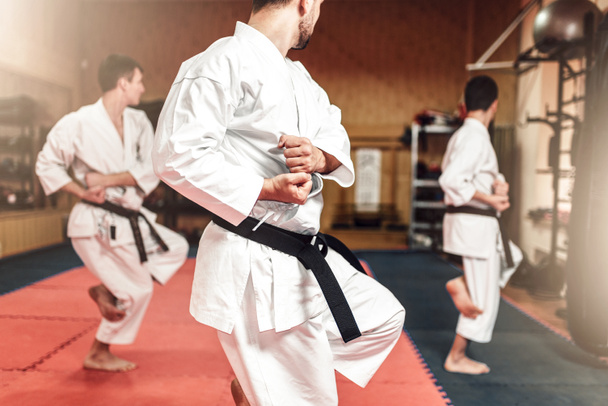Πολεμικών τεχνών καράτε master και μαθητές σε λευκή στολή και μαύρες ζώνες, καταπολέμηση της κατάρτισης στο γυμναστήριο - Φωτογραφία, εικόνα