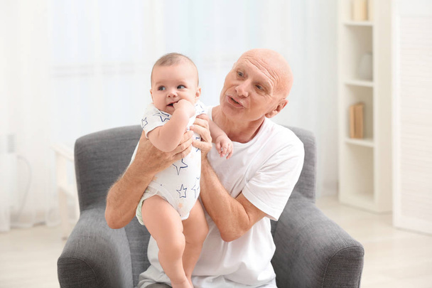 Senior man playing with his little grandchild at home - Foto, Bild