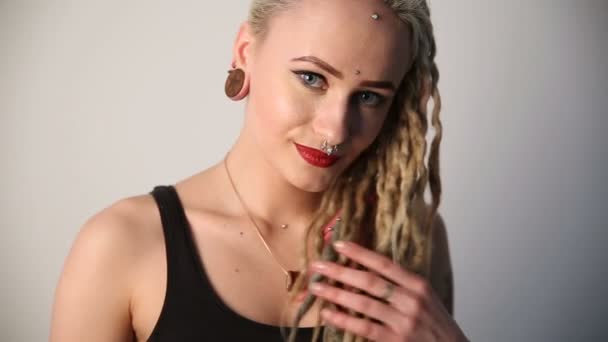 moderne jeugd. Portret van een rustig mooi meisje van genormaliseerde verschijning - dreadlocks, piercings en tatoeages. - Video