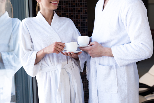 cropped shot of couple in bathrobes drinking tea in spa center - Fotografie, Obrázek