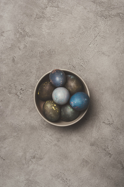 top view of easter eggs in bowl on concrete surface  - Foto, Imagem