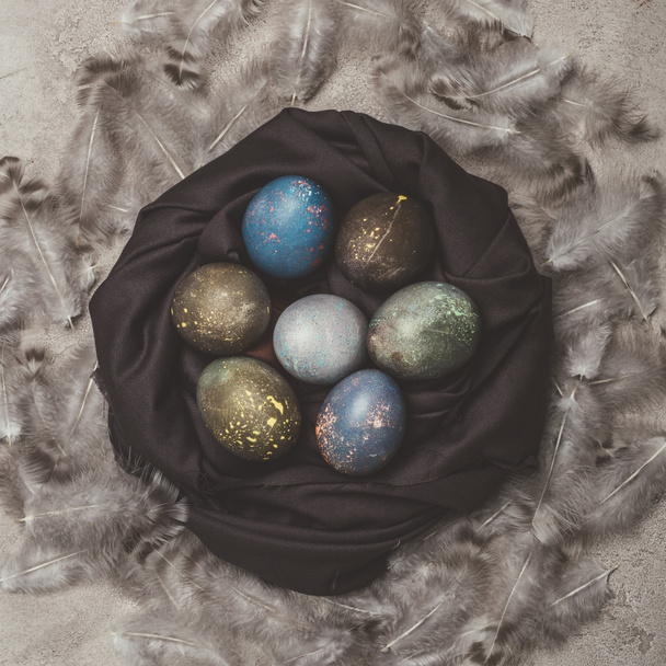 top view of shabby easter eggs in nest with feathers - Foto, Bild