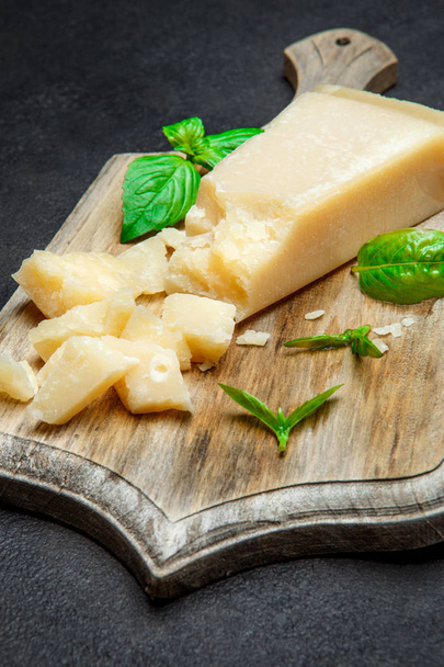 Pieces of parmesan cheese on concrete background - 写真・画像