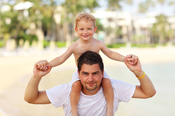 Kuva isästä pitämässä hauskaa rannalla pienen poikansa kanssa
 - Valokuva, kuva