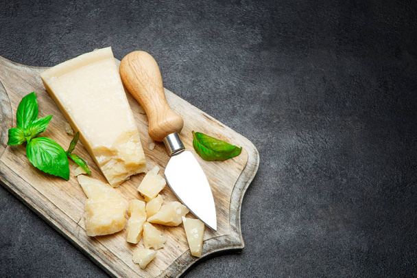 Pieces of parmesan cheese on concrete background - 写真・画像