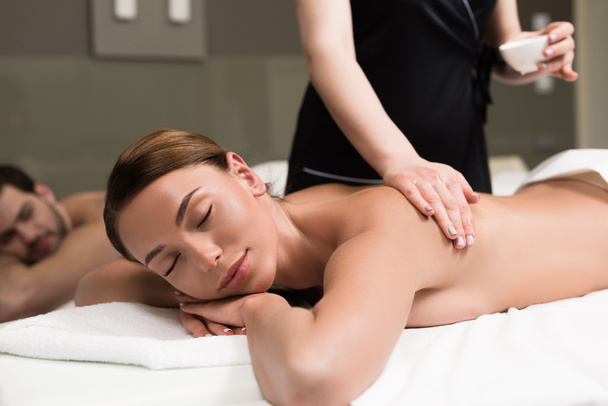 young woman with closed eyes having body massage in spa salon - Photo, Image