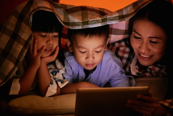 В'єтнамських дітей і матері, що лежить під ковдрою і дивитися мультфільми разом - Фото, зображення