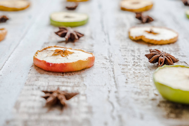 scattered slices of dried apples and star anise, on a wooden surface toned background decoration design - 写真・画像
