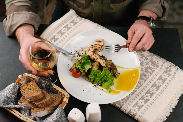 Levágott képe ember enni griiled húst, Villa és kés - Fotó, kép