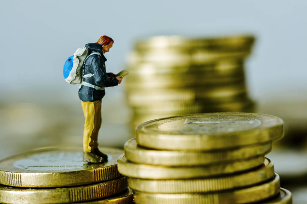viajero en miniatura en una pila de monedas de euro
 - Foto, imagen
