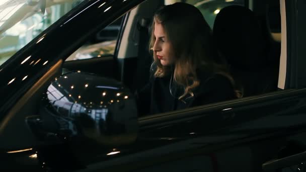 Brunette Woman in Luxury Car salon holding hands on steering wheel - Video
