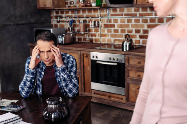 selective focus of woman looking at pensive husband at table at home, financial problems concept - Photo, Image