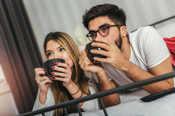 junges glückliches Paar trinkt Kaffee im Bett - Foto, Bild