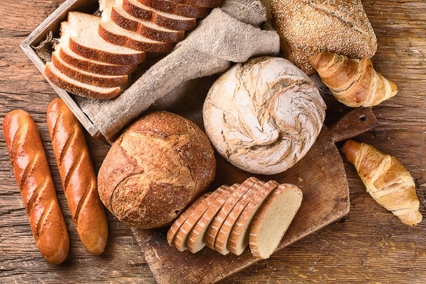 Fresh baked bread on rustic wooden background - Photo, image
