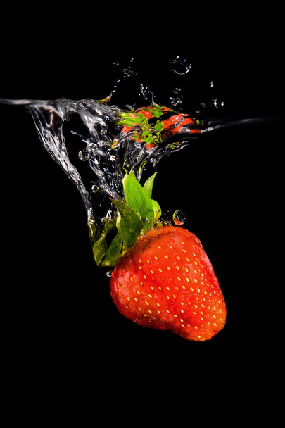 Strawberry drop into water - Foto, afbeelding