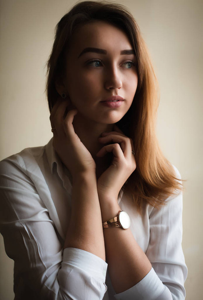 Elegantní brunetka žena v bílé košili pózuje na pokoji - Fotografie, Obrázek