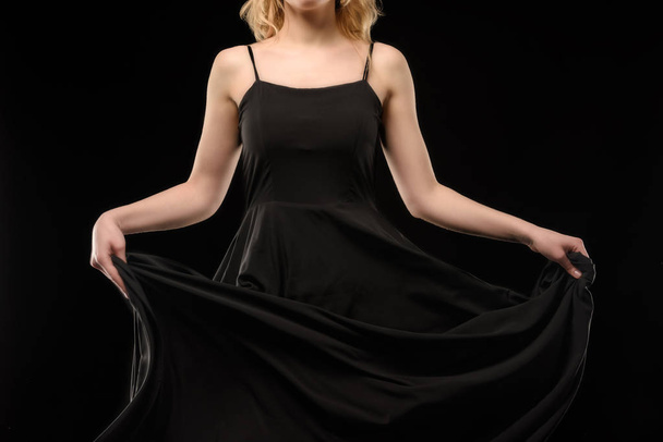 cropped view of girl posing in black dress, isolated on black - Фото, изображение