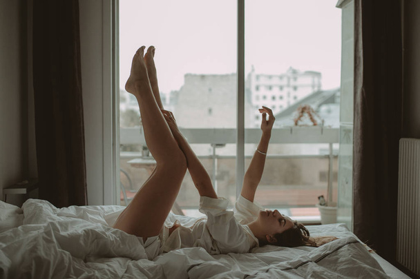Woman lying on the bed in the morning - Фото, изображение
