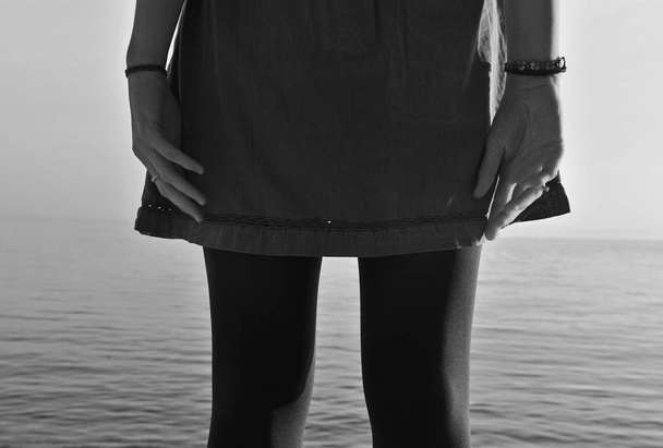 σιλουέτα ενός κοριτσιού που στέκεται στη θάλασσα - Φωτογραφία, εικόνα