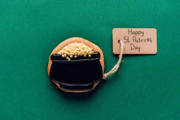 Draufsicht auf Sahnehäubchen in Form eines Topfes mit Münzen auf grünem, st patricks day concept - Foto, Bild