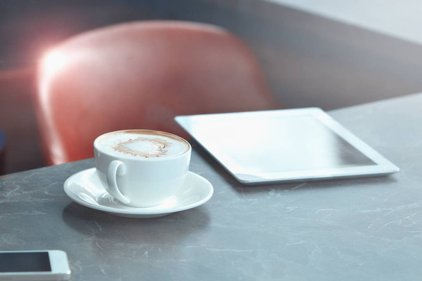 Cup of coffee, smartphone and touch pad on marble table background - Photo, Image