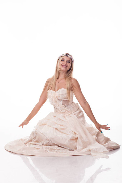 блондинка в білій сукні, на зображенні принцеси. Позування сидячи. ізольована фотографія на білому тлі, з різними емоціями
 - Фото, зображення