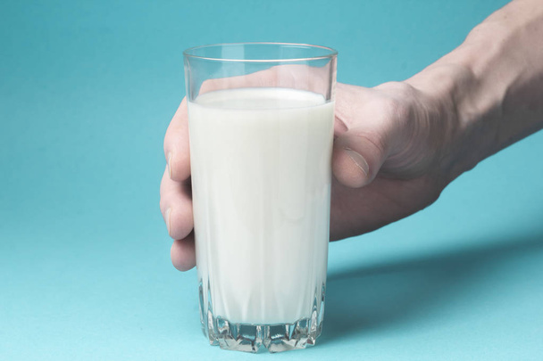 A glass of milk in a hand. - Photo, Image